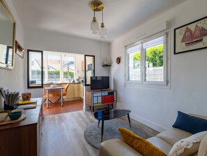 A modern living room with a TV, sofa, and dining area.