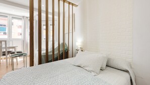 Une chambre à coucher avec un lit, une cloison en bois, un bureau et une chaise.
