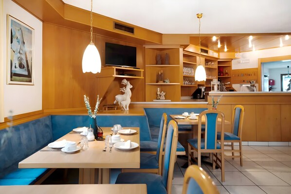 Un restaurante con cabinas, una zona de bar y una televisión.