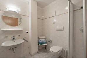 A bathroom with a sink, mirror, toilet, and shower. - Room 'Pension Waldheim  11' with Mountain View, Shared Garden and Wi-Fi (Ahrntal)