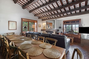 A dining area with a wooden table, woven placemats, and leather seating.