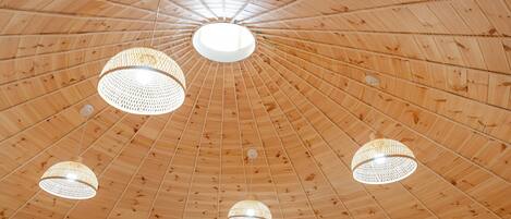 A wooden ceiling with a radial pattern and multiple hanging light fixtures.