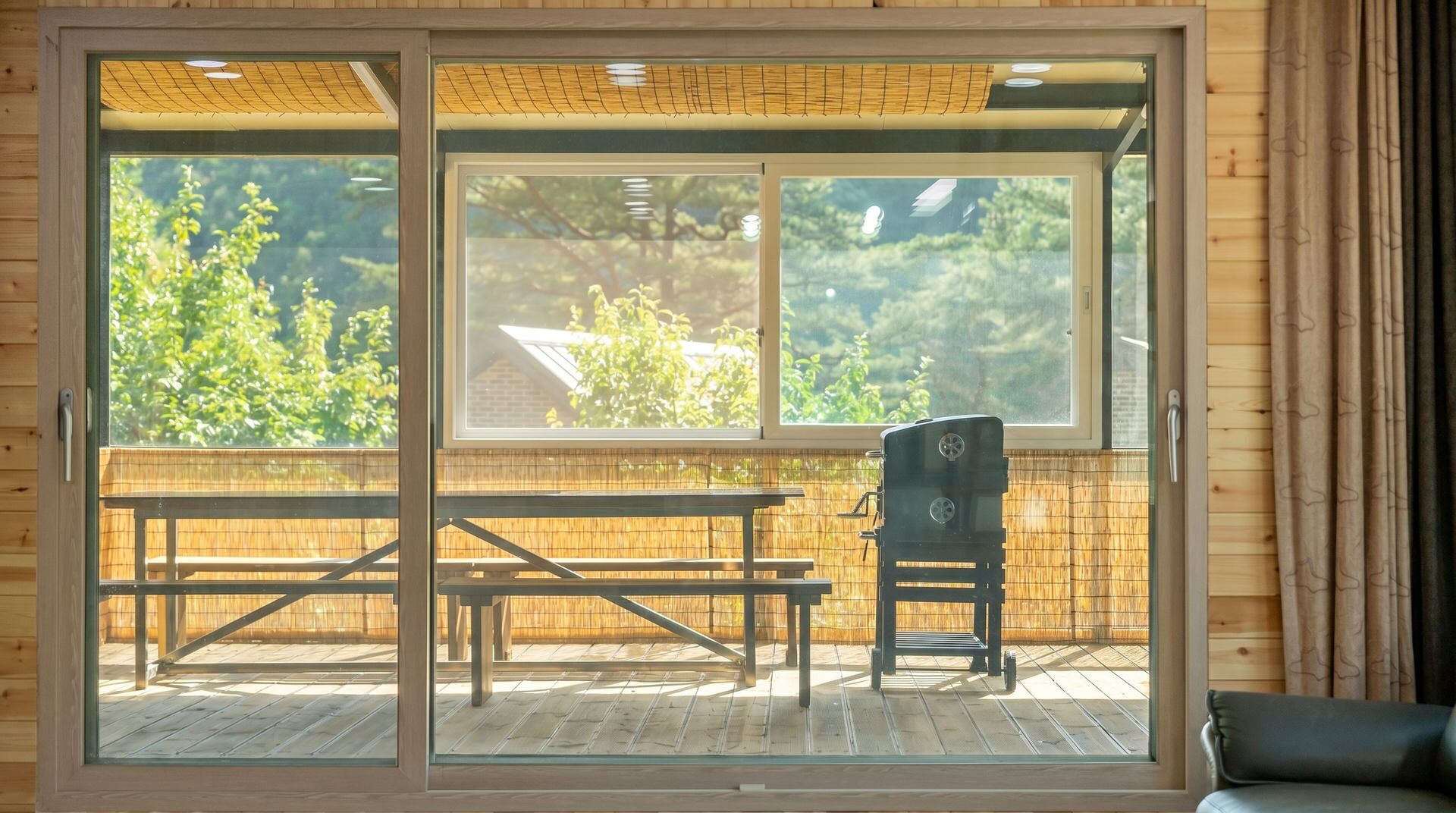 A room with a sliding glass door leading to an outdoor patio with a wooden table and chairs.