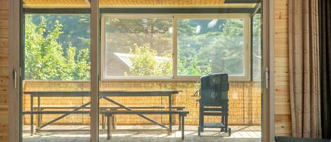 A room with a sliding glass door leading to an outdoor patio with a wooden table and chairs.