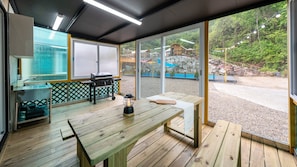 A modern kitchen with a wooden table, a grill, and a lantern. - Gapyeong Castra Glamping (Gapyeong)