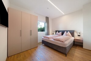 A bedroom with a bed, wardrobe, bedside table, and a window. - Apartment 'Rosalie  5' with Mountain View, Shared Pool and Wi-Fi (Lana)