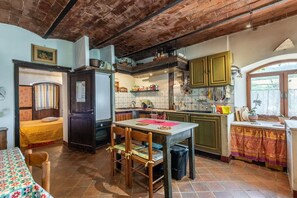 Una cocina compacta con comedor, una cama y un baño pequeño.
