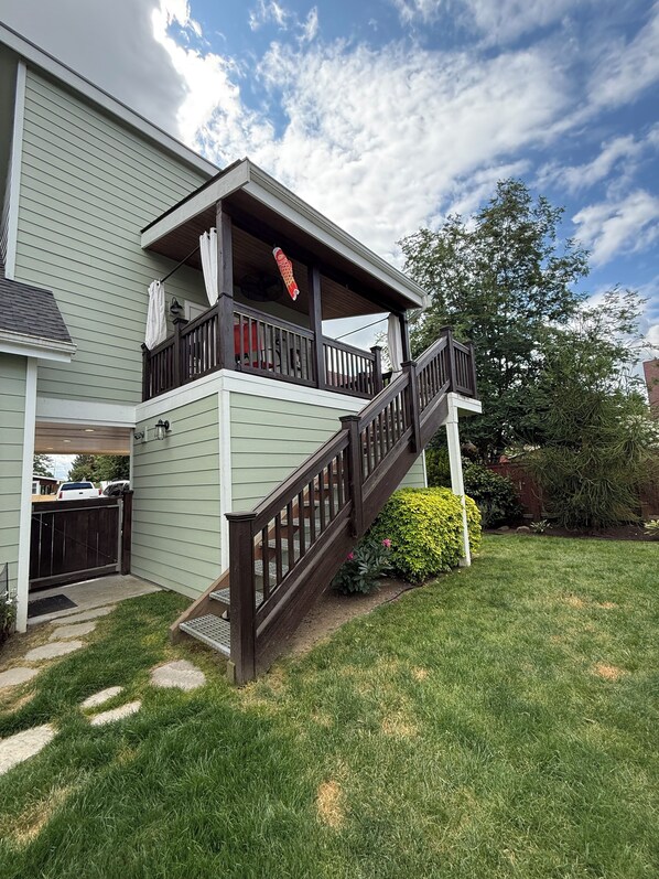 A two-story house with a wooden staircase leading to a balcony, a fenced backyard, and a well-maintained lawn. - Birds Nest, Only blocks to downtown Snohomish (Snohomish)