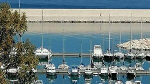 A marina with boats docked, a sailboat in the distance, and a clear sky. - 'Corallo - Casa Vacanze' Apartment with Sea View, Wi-Fi and Air Conditioning (Balestrate)