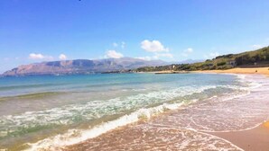 A beach with clear water, a sandy shore, and distant mountains. - 'Corallo - Casa Vacanze' Apartment with Sea View, Wi-Fi and Air Conditioning (Balestrate)