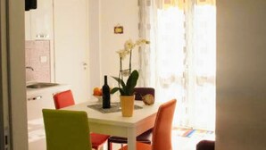 A dining area with a table, chairs, and a potted plant.