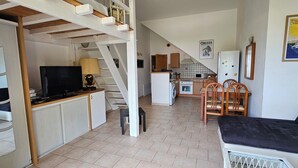 Un espacio habitable compacto con cocina, comedor y zona de descanso.