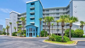 A multi-story hotel with a distinctive blue and white facade, featuring balconies and a central entrance.