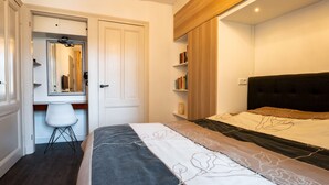 Une chambre à coucher moderne avec un lit, une table de chevet et une armoire.