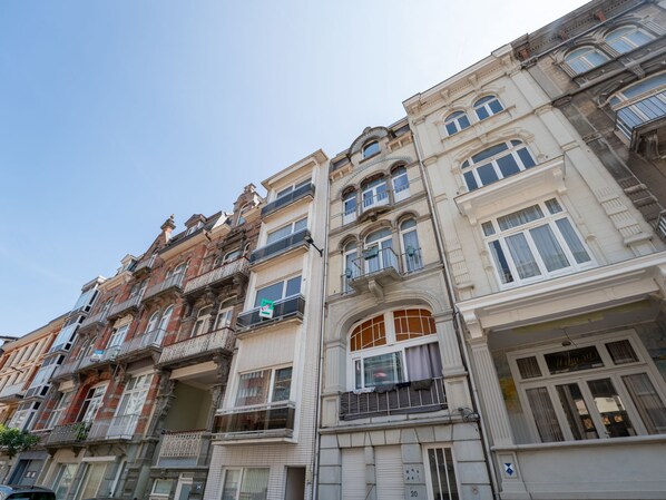 A row of multi-story buildings with balconies and large windows.