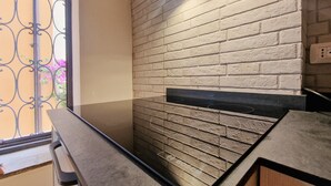 A kitchen with a brick wall, a black countertop, and a window with a metal gate. - Apartment 'Gianni Rio Elba' with Wi-Fi and Air Conditioning (Rio Nell'elba)