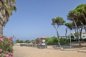 A park with a playground, a red-roofed pavilion, and a clear blue sky. - 'Mirador De La Atalaya' Apartment with Sea View, Private Terrace, Garden & Wi-Fi (Conil de la Frontera)