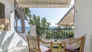 A balcony with a table and chairs, overlooking a scenic view. - 'Mirador De La Atalaya' Apartment with Sea View, Private Terrace, Garden & Wi-Fi (Conil de la Frontera)