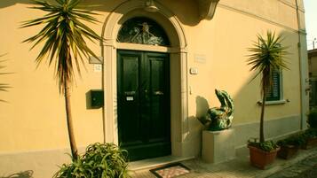 A building with a green door, numbered 42, and a small sculpture on the porch.