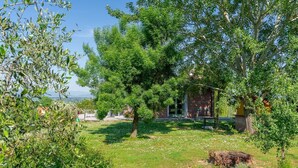 A rustic house surrounded by lush greenery and a clear sky. - Holiday Home 'Dulù - Luminoso Spazio' with Shared Garden, Balcony and Wi-Fi (Capannori)