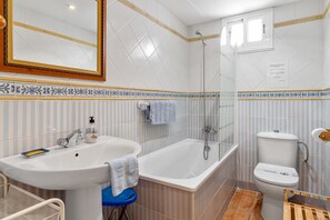 Un bagno con vasca, water e lavandino.