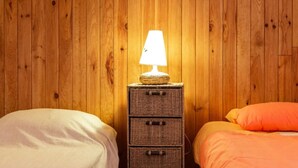 A room with two beds, a nightstand with a lamp, and a wooden wall. - "Cytise" Room with Private Terrace, Shared Garden, Wi-Fi, E-Bike Friendly (L'Épine)