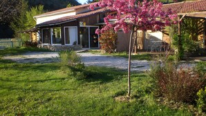 A house with a patio, a garden with a tree, and a mountain in the background. - "Cytise" Room with Private Terrace, Shared Garden, Wi-Fi, E-Bike Friendly (L'Épine)
