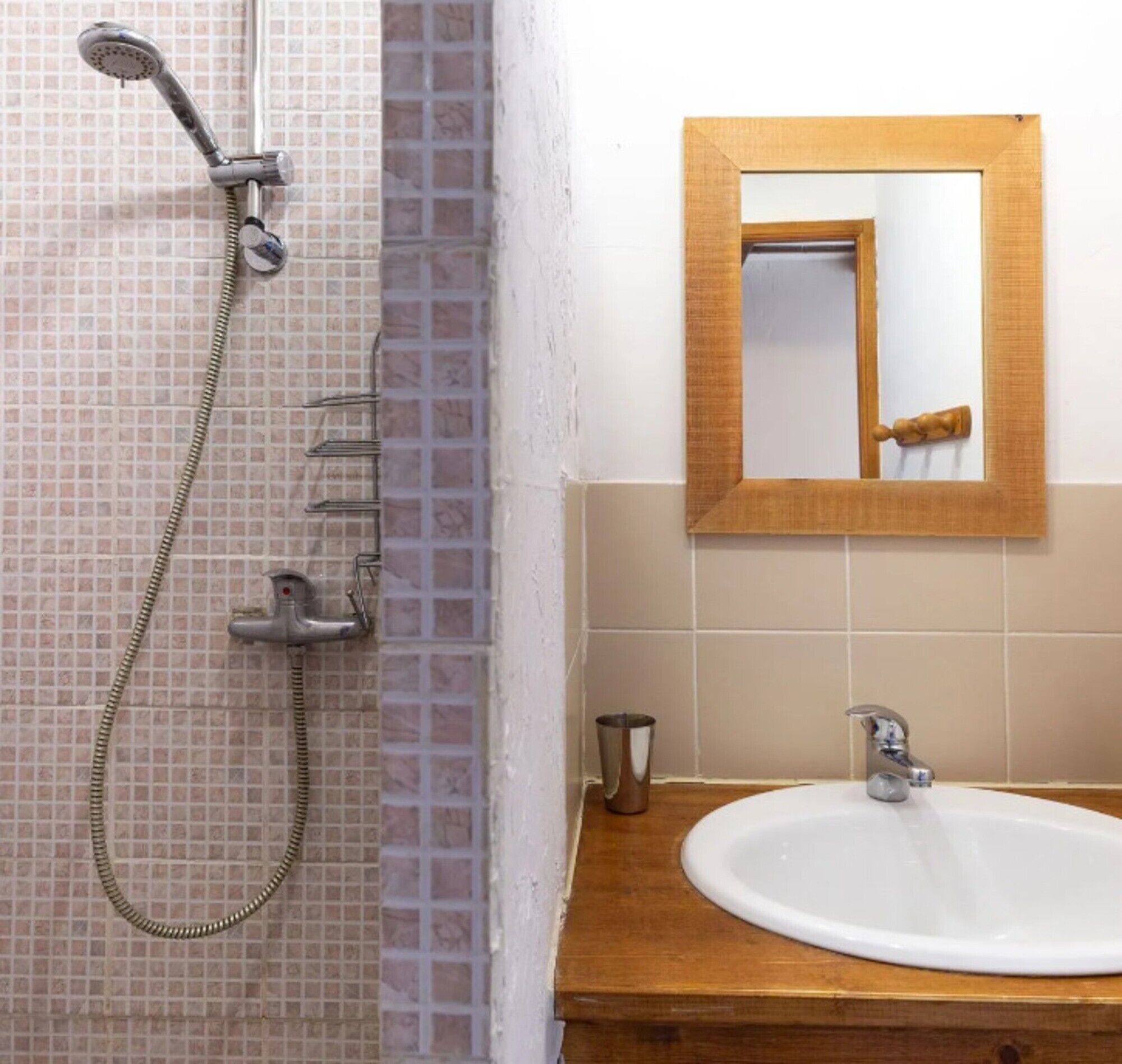 Une salle de bain avec une douche, un lavabo et un miroir.