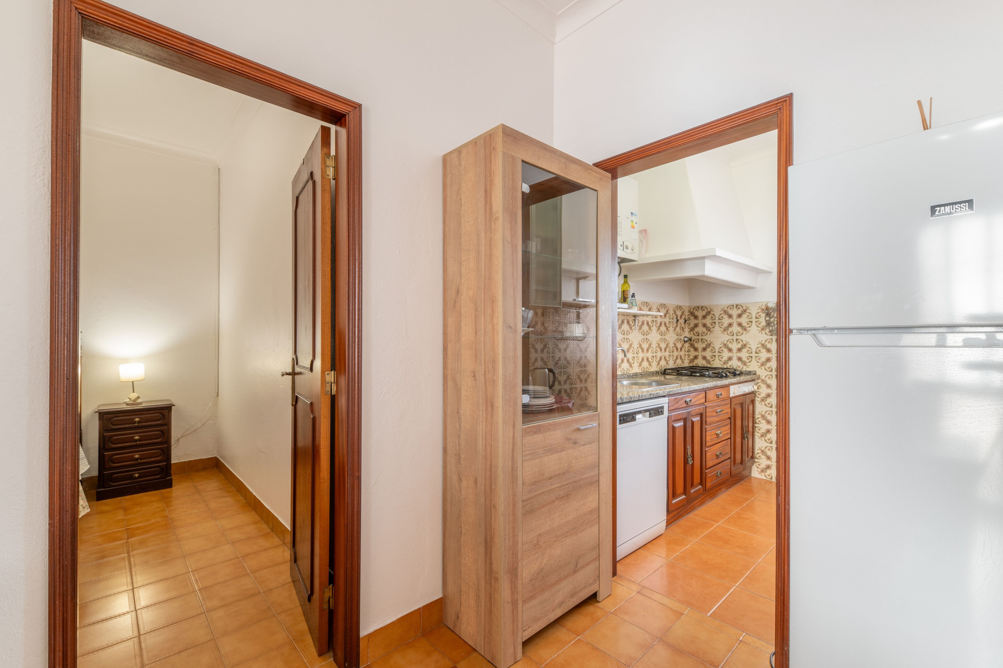 Eine Küche mit Kühlschrank, Herd und Holzschränken.