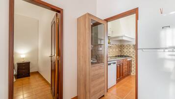 Eine Küche mit Kühlschrank, Herd und Holzschränken.