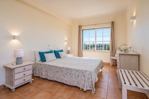 A bedroom with a bed, bedside tables, a desk, and a window with a view. - T2 Plaza Resort Condominium with Pool (Portimão)