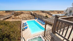A wooden deck with a swimming pool, lounge chairs, and a hot tub overlooking a beach. - OCEANFRONT, wild horses, private pool, hot tub-4x2275, Over at Carova (Carova Beach)