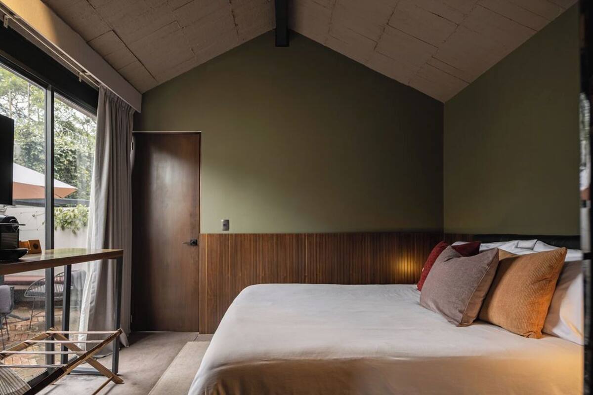 Ein Schlafzimmer mit Bett, Schreibtisch und Fenster.