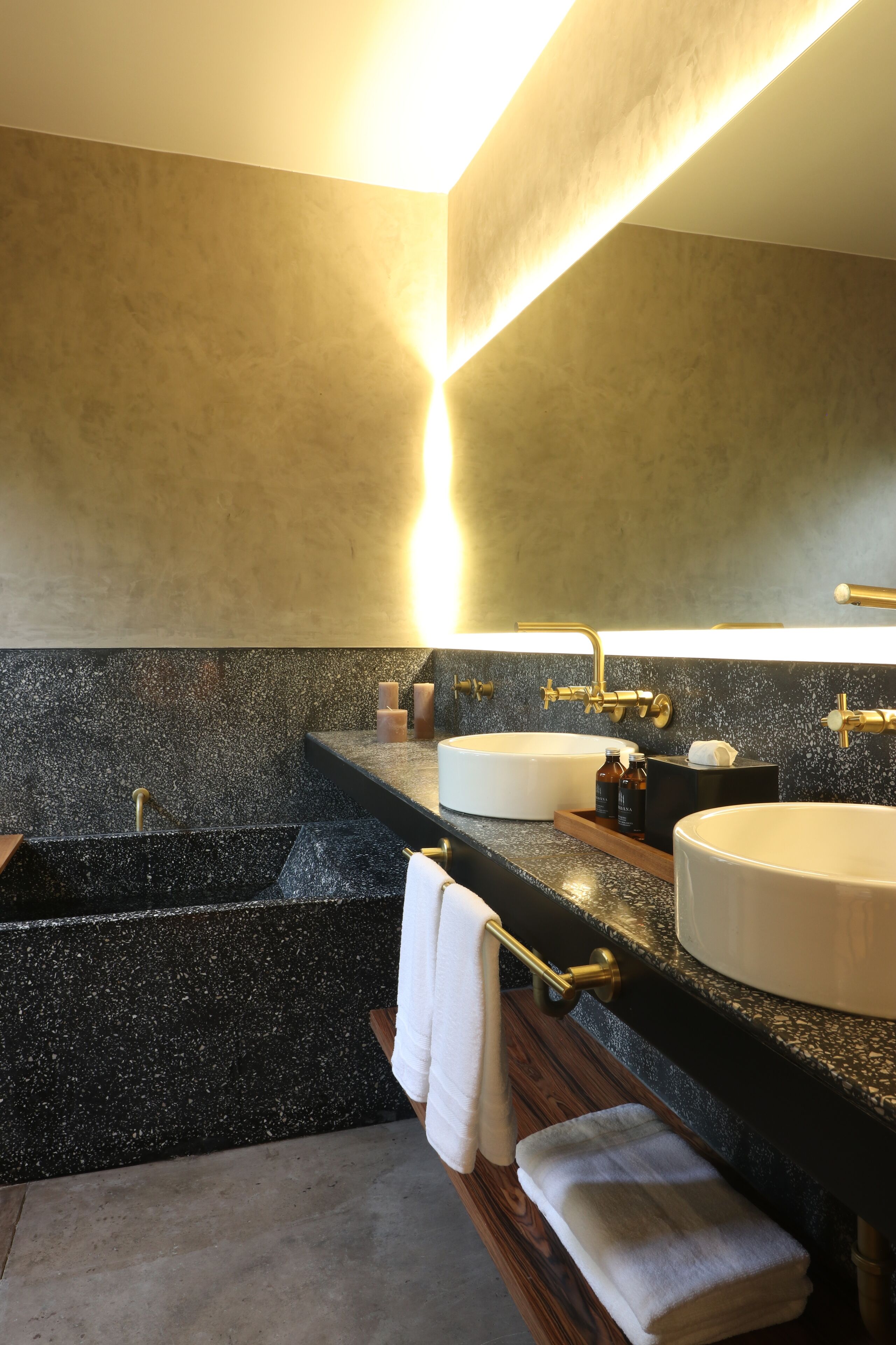 Une salle de bain moderne avec deux lavabos, une baignoire et un grand miroir.