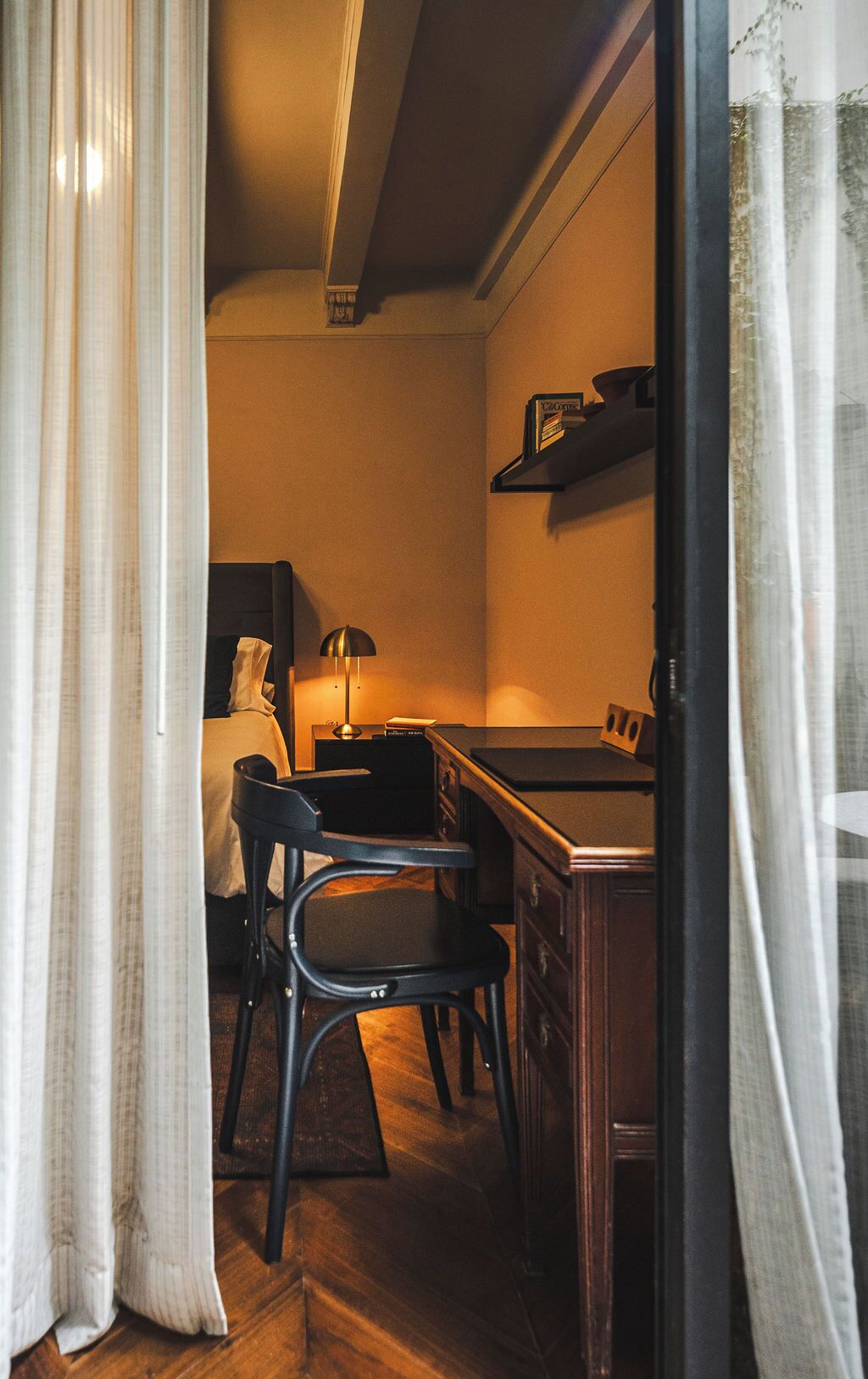 A compact kitchen with a dining area, featuring a stove, chairs, and a table.