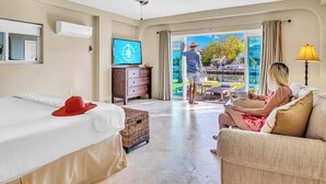 A hotel room with a bed, a television, a ceiling fan, a window, and a view of the outside. - Waterfront / Ocean Access Canal / Kamp Key / Homes (Islamorada)