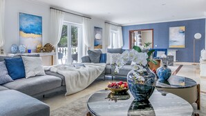 Un salon moderne avec un canapé gris, une table basse et des vases décoratifs.
