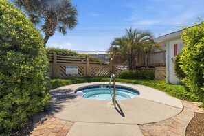 Une piscine entourée d’une clôture en bois, avec une pancarte « Bienvenue » et un indicateur de profondeur indiquant « 3 pieds ».