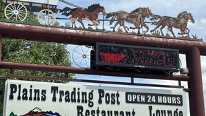A sign for Plains Trading Post Restaurant Lounge with a digital display above it. - plains motel  (Douglas)