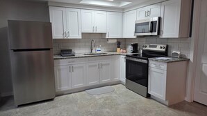 A modern kitchen with white cabinets, stainless steel appliances, and a granite countertop.