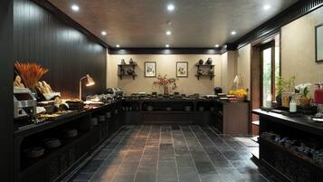 A spacious kitchen with dark wood paneling, a central island with various kitchen items, and a tiled floor.