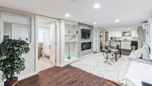 Een moderne woonkamer met een open haard, een eethoek en een keuken.