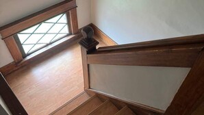 A wooden staircase with a glass window at the top, leading to a room with a wooden floor. - The Spruce House  Family 4BR 2 Bath, Great Location, In Ogallala, Close to Lake McConaughy (Ogallala)