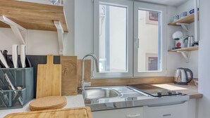 Eine moderne Küche mit Edelstahl-Spüle, Holz-Arbeitsplatte und integriertem Geschirrspüler.