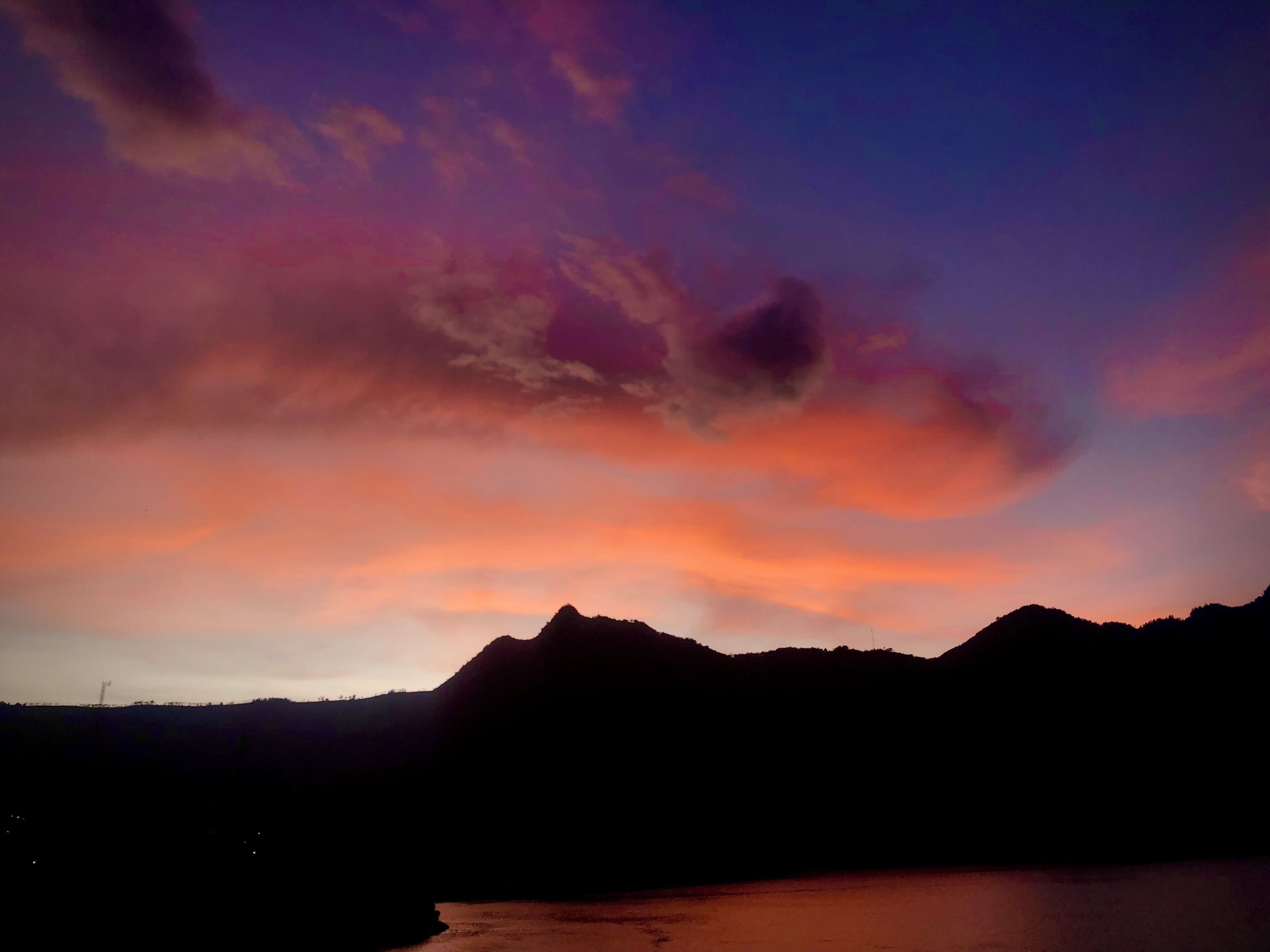 A mountain landscape at dusk with a clear sky.