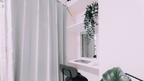 A modern bathroom with a white sink, a mirror, and a black chair. - Minimalist Loft 602 (Osaka)