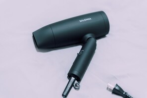 A black cylindrical device with a coiled cord and a metal connector, labeled "SALONIA." - Minimalist Loft 602 (Osaka)