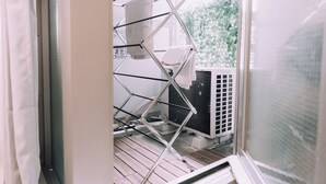 A laundry area with a drying rack and an air conditioning unit. - Minimalist Loft 602 (Osaka)