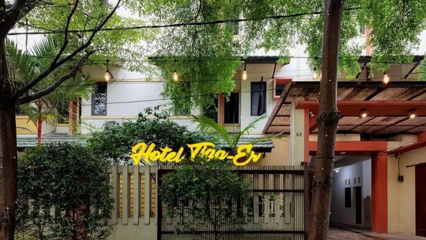 A gated entrance to a hotel with a sign reading "Hotel Tiga-Ev."