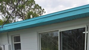 An outdoor patio area with wicker furniture and a sliding glass door leading to a covered porch. - Peaceful accomodation. Walking distant to Port Richey waterfront restaurants. (Port Richey)